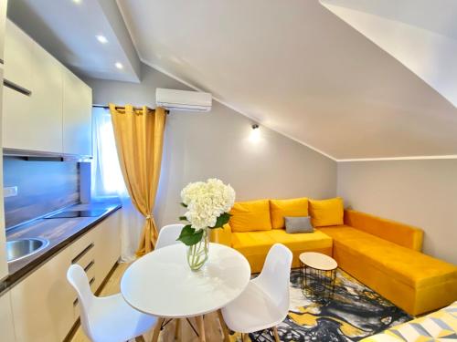 a living room with a yellow couch and a table at Villa Blanca in Risan