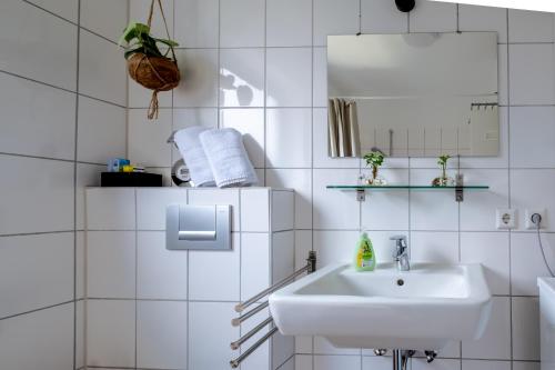 a white bathroom with a sink and a mirror at Studio Fayence - EMMA, Netflix, WiFi, Workspace in Karlsruhe