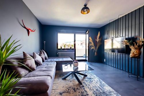 a living room with a brown couch and blue walls at Studio Fayence - EMMA, Netflix, WiFi, Workspace in Karlsruhe