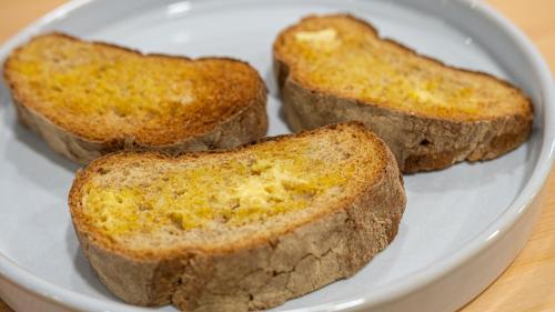 three pieces of bread on a white plate at The Village House by CDV in Carrazeda de Anciães