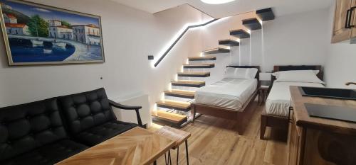 a room with a staircase with two beds and a couch at Bujtina Gjyshi Ilo in Pogradec