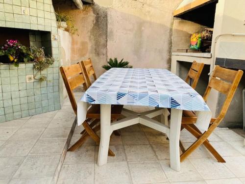una mesa con 2 sillas y una mesa de baldosas azules y blancas en Monolocale in un piccolo paradiso, en Tramatza