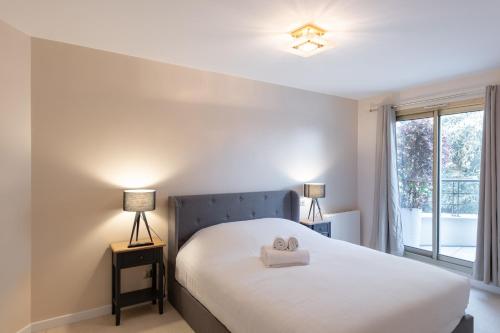 une chambre avec un lit avec deux serviettes dessus dans l'établissement L'HAUTERIVE - Magnifique T3 piscine tennis Caluire, à Caluire-et-Cuire