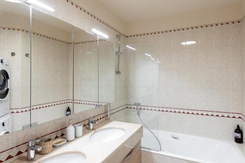 卡魯雷埃奎耶的住宿－L'HAUTERIVE - Magnifique T3 piscine tennis Caluire，一间带水槽、浴缸和镜子的浴室