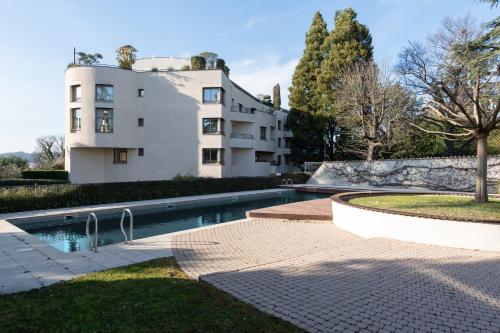 une maison avec piscine devant un immeuble dans l'établissement L'HAUTERIVE - Magnifique T3 piscine tennis Caluire, à Caluire-et-Cuire