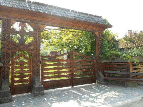 a wooden gazebo with a wooden fence at PENSIUNEA DENISIA in Vadu Izei