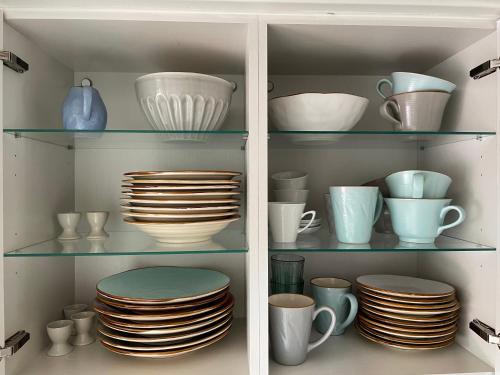a cabinet filled with plates and cups and bowls at Haus am Grimnitzsee mit Garten in Joachimsthal