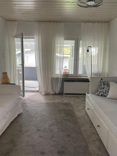 a white bedroom with two beds and a mirror at Haus am Grimnitzsee mit Garten in Joachimsthal