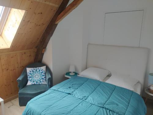 a bedroom with a bed and a chair at Gîte La Pironnière - Piscine, Nature, au bord de la Rivière in Montreuil-sur-Maine