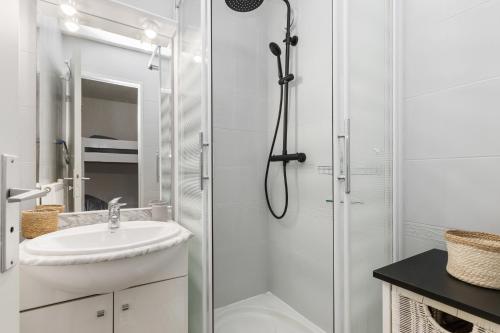 une salle de bain blanche avec une douche et un lavabo dans l'établissement Little Venezia by POM, au bord de l'eau, parking, au Cap d'Agde