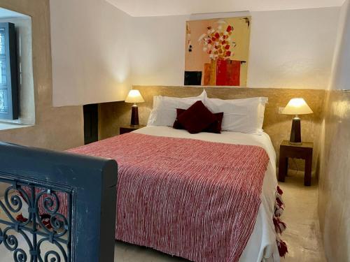a bedroom with a large bed with a red blanket at Riad Magellan Yoga and Spa in Marrakesh