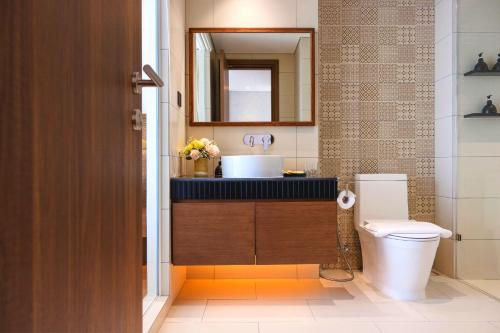 a bathroom with a sink and a toilet and a mirror at Mandala Hotel & Spa Phú Yên - 24hours Stay in Tuy Hoa