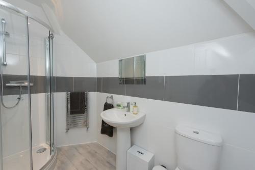 a white bathroom with a sink and a shower at Stylish ground floor apartment in Margate