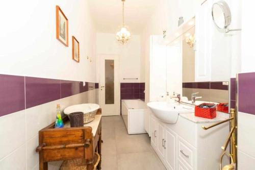 ein weißes Badezimmer mit einem Waschbecken und einem Spiegel in der Unterkunft Appartamento Turati 74 in Turin