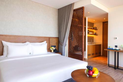 a hotel room with a bed and a bowl of fruit on a table at Mandala Hotel & Spa Phú Yên - 24hours Stay in Tuy Hoa