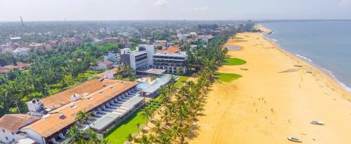 een luchtzicht op een strand met een hotel en een gebouw bij Goldi Sands Hotel in Negombo