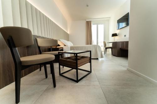 a hotel room with a table and chairs and a bed at Hotel Falli in Porto Cesareo