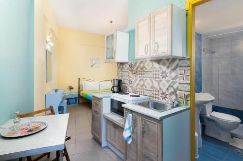 Il comprend une petite cuisine avec un lavabo et des toilettes. dans l'établissement Afroditi Apartments, à Makry Gialos