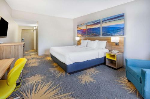 a hotel room with a bed and a television at Days Inn by Wyndham Roanoke Near I-81 in Roanoke