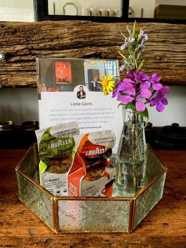 a vase with flowers and cookies in a box at ALTE SCHULE WITTENBERG, 3 Ferienwohnungen für bis zu 12 Personen, an der Elbe, mit Garten in Lutherstadt Wittenberg