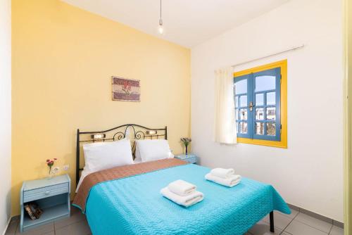 a bedroom with a bed with two towels on it at Afroditi Apartments in Makry Gialos