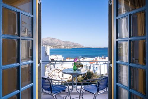 a balcony with a table and chairs and a view of the ocean at Afroditi Apartments in Makry Gialos