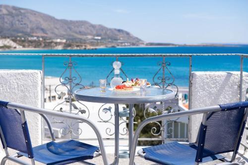a table and chairs on a balcony with the beach at Afroditi Apartments in Makry Gialos