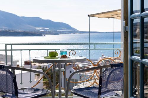 a table and chairs on a balcony with a view of the ocean at Afroditi Apartments in Makry Gialos