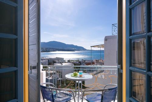 a balcony with a table and chairs and a view of the ocean at Afroditi Apartments in Makry Gialos