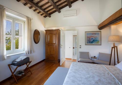 1 dormitorio con 1 cama, 2 sillas y ventana en Villa LeMarche b&b, en Rustico