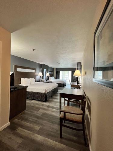 a hotel room with a bed and a desk at Best Western Americana in Dinuba