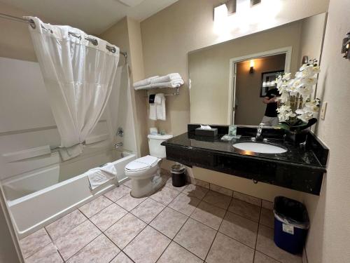 a woman taking a picture of a bathroom at Best Western Americana in Dinuba