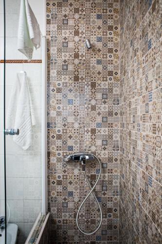 a shower in a bathroom with a tiled wall at Hostal Restaurante El Paso in Bailén