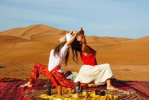 Dos mujeres sentadas en una manta en el desierto en berber sahara, en Zagora