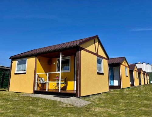 a yellow house with a large open door at Domki Grażyna in Jastarnia