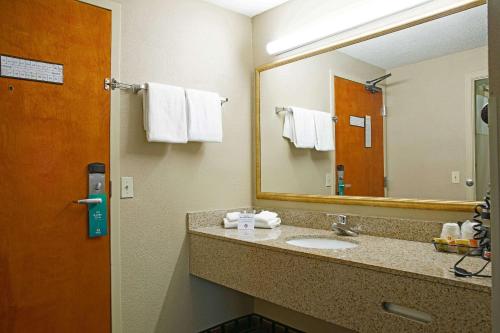 ein Badezimmer mit einem Waschbecken, einem Spiegel und Handtüchern in der Unterkunft Quality Inn Raynham - Taunton in Raynham