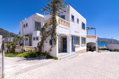 a white building on the side of a street at Afroditi Apartments in Makry Gialos