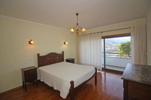 a bedroom with a bed and a large window at Quinta do Grilo in Vieira do Minho