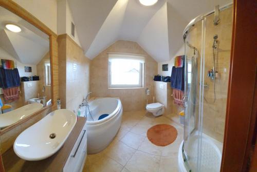 a bathroom with a tub and a sink and a shower at Villa Leika - Panoramablick am Riesengebirge in Mysłakowice