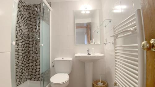 Baño blanco con aseo y lavamanos en C12 - Apartamento Casa Llorgodo 3 - Villmor, en Cerler
