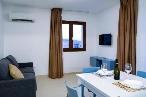 ein Wohnzimmer mit einem Sofa und einem Tisch mit Weingläsern in der Unterkunft SOL Y MAR Camere e Appartamenti in Castellammare del Golfo