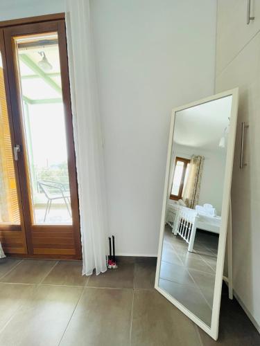 a mirror in a room with a door at Aricobé in Ancient Epidavros