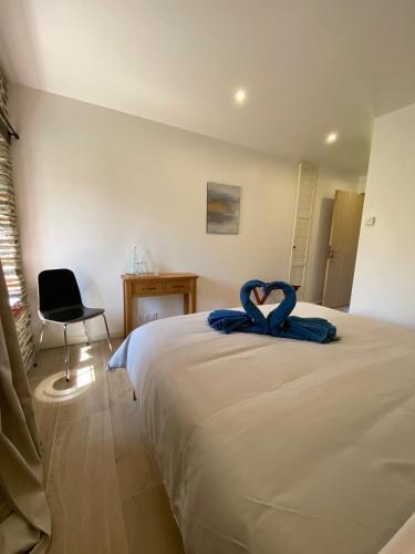 a bedroom with a bed with blue sheets and a chair at Domaine de Kerdavid - Chambres d'hôtes à Remungol in Évellys