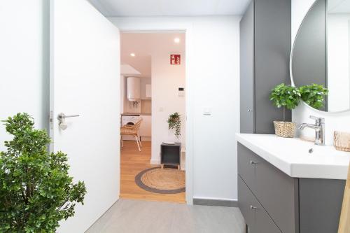 ein Badezimmer mit Waschbecken und Spiegel in der Unterkunft Global Properties, Apartamento nuevo en la playa de Canet d'en Berenguer in Canet d'en Berenguer