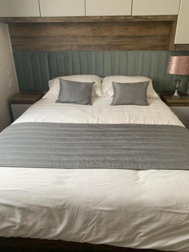 a large white bed with two pillows on it at Brookwood Sea View 14 in Dunoon