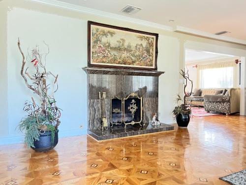 a living room with a fireplace with a painting on the wall at NoHo Luxury Oasis I saltwater pool-spa I sleeps up to 8 I 15 mins from Hollywood in Los Angeles