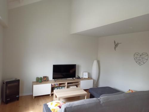 a living room with a couch and a flat screen tv at APARTAMENTO A CASIÑA in Cangas de Morrazo