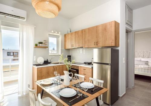 uma cozinha com uma mesa e um frigorífico de aço inoxidável em Cozy Apartment Evdoxia (2), on foot to the beach em Chania
