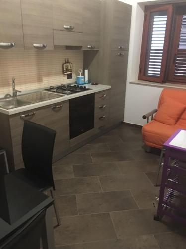 a kitchen with a stove and an orange couch at Susanna 1 in Palizzi Marina