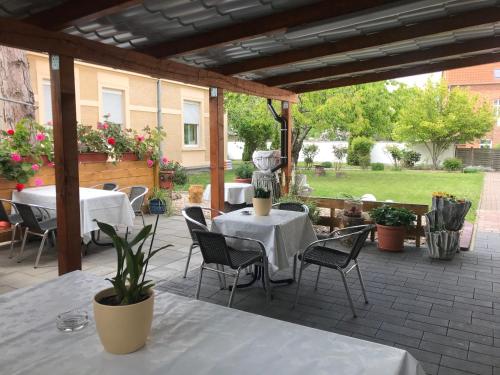 a patio with two tables and chairs and a statue at PensionLien in Köthen